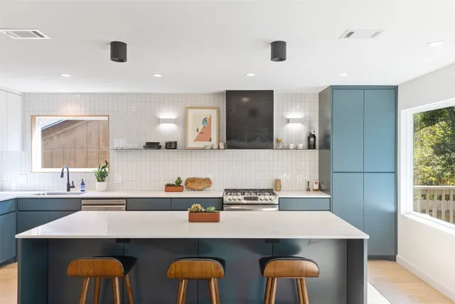 a kitchen with a sink a window and chairs