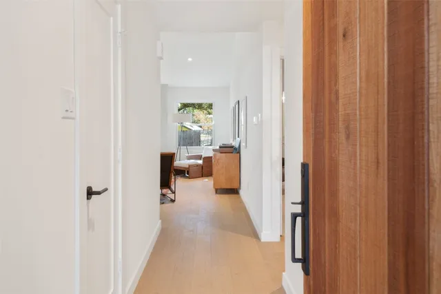 a view of a hallway with a livingroom and a bathroom with sink