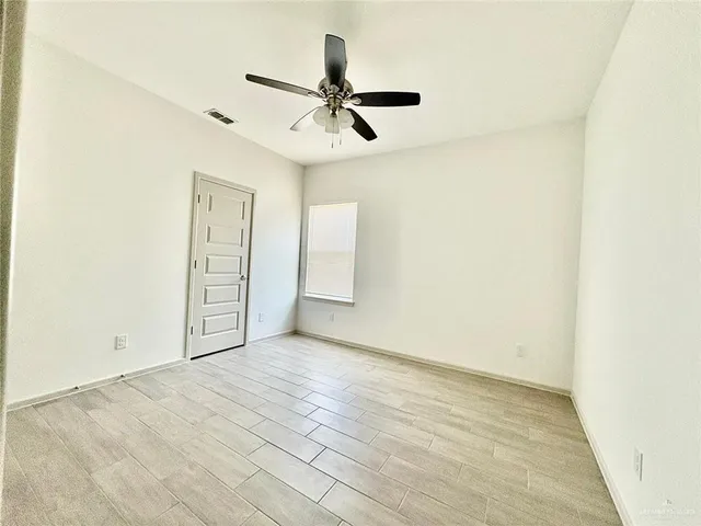 an empty room with closet and windows
