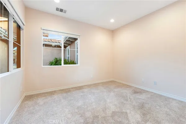 an empty room with closet and windows