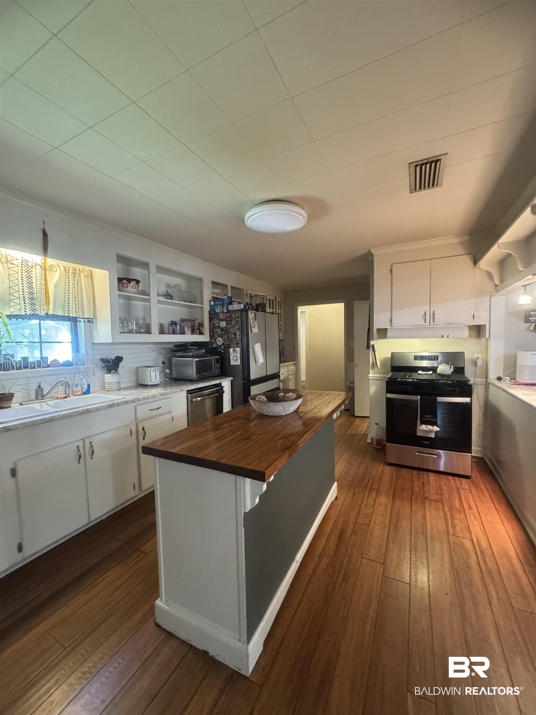 3097 Old Castleberry Road Brewton, AL 36426 - Photo 6 of 49 Kitchen featuring appliances with stainless steel finishes, white cabinetry, butcher block counter, dark wood-type flooring, and sink