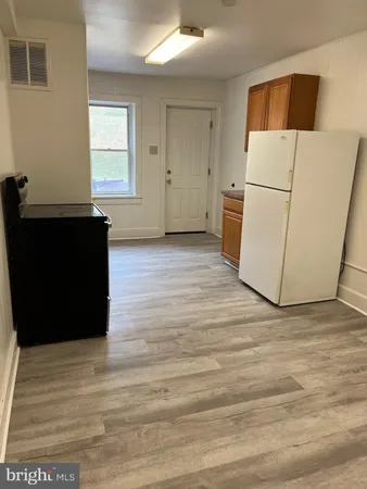 a view of a refrigerator in kitchen and wooden floor