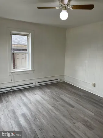 an empty room with wooden floor and window