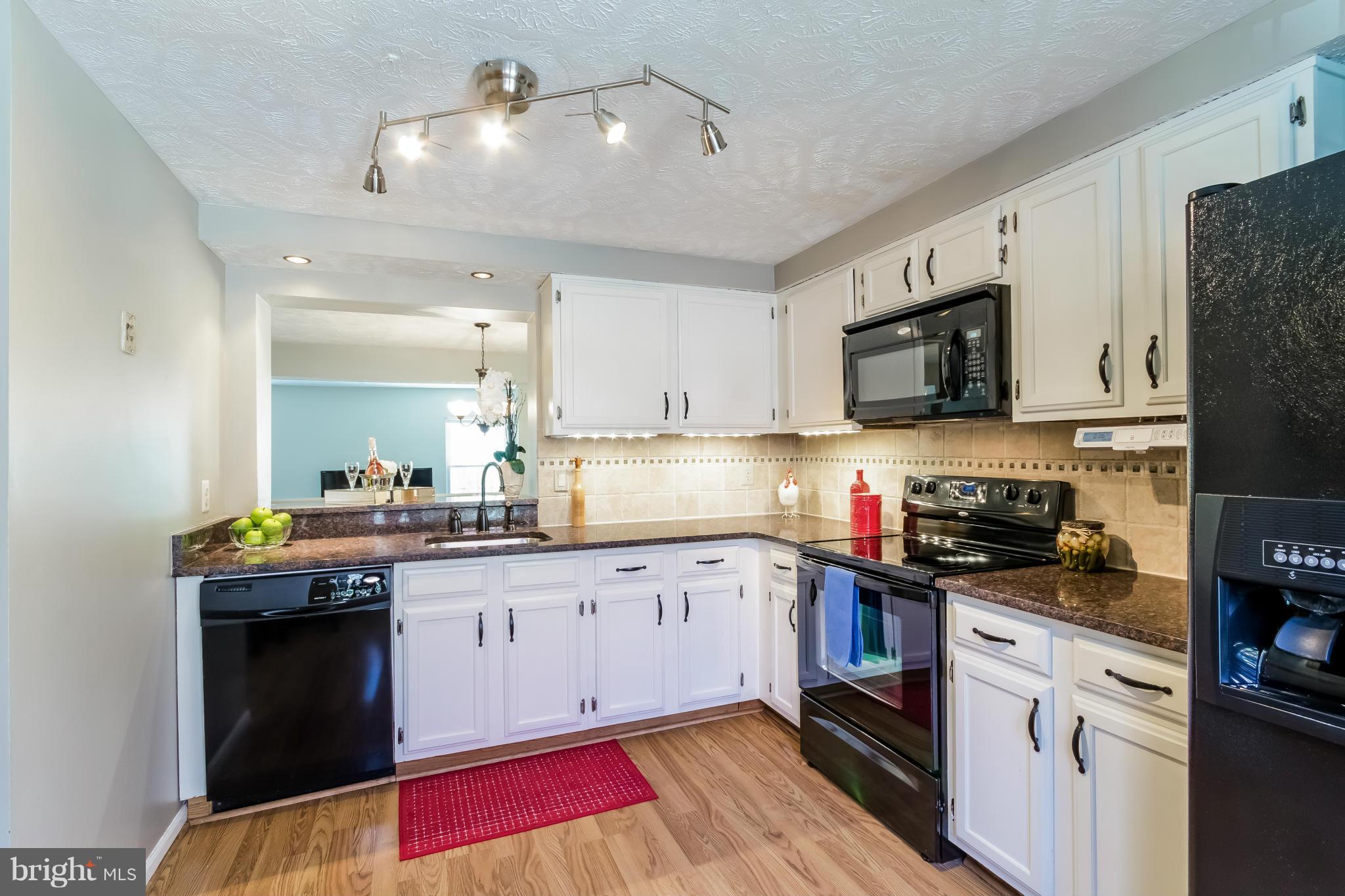 1547 Autumn Ridge Circle Reston, VA 20194 - Photo 7 of 30 a kitchen with granite countertop a stove top oven a sink dishwasher and a refrigerator with wooden floor