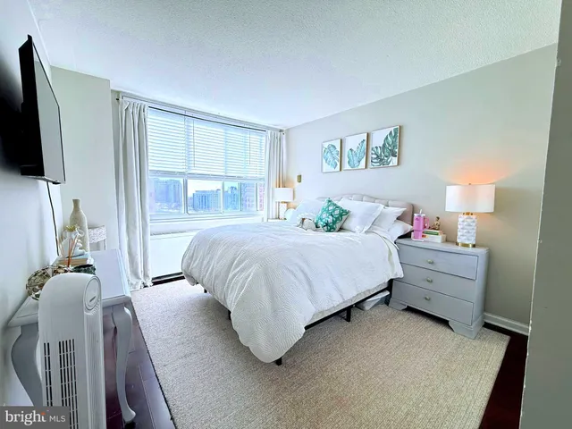 a bedroom with a bed and a painting on the wall