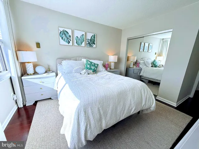 a bedroom with a bed a flat screen tv and a large window