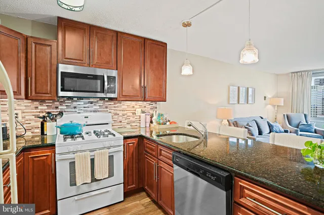 a kitchen with stainless steel appliances granite countertop a sink stove and microwave