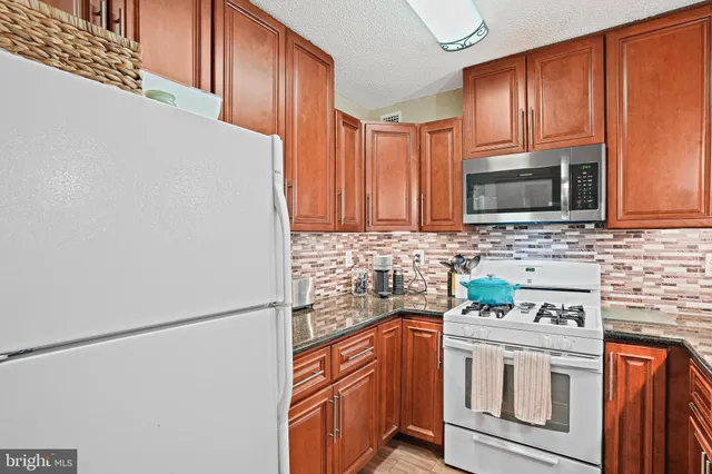 a kitchen with stainless steel appliances white cabinets and a refrigerator