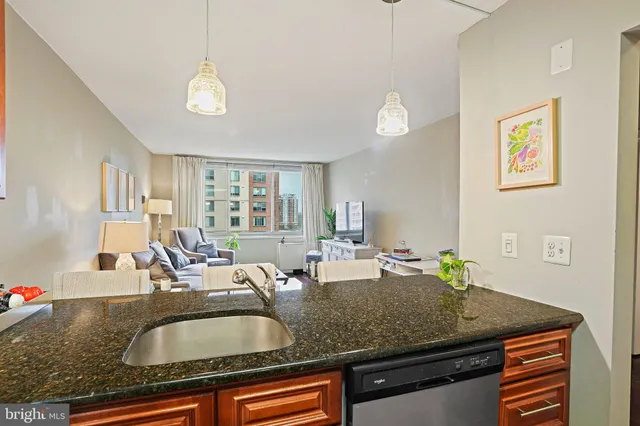 a room with granite countertop a sink a counter top space and living room area