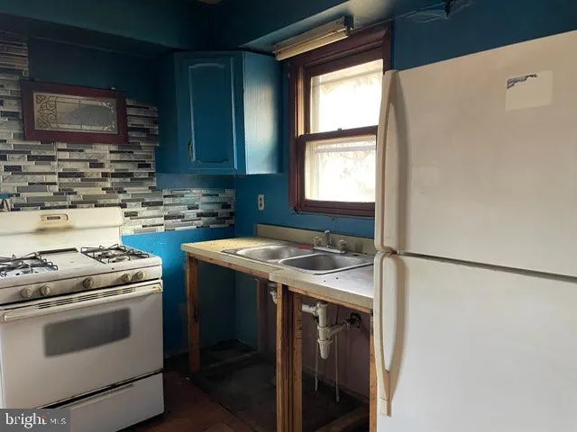 a kitchen with stainless steel appliances granite countertop a refrigerator a stove a sink and a microwave