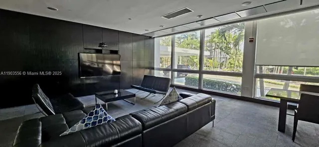 a living room with furniture and a floor to ceiling window
