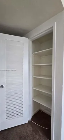 a kitchen with a sink a refrigerator and cabinets
