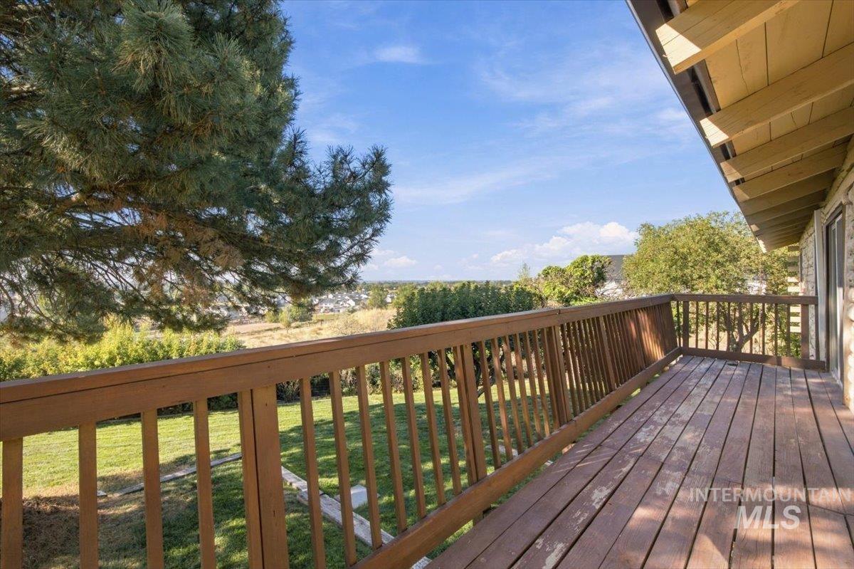 10201 Willis Road Middleton, ID 83644 - Photo 34 of 38 Expansive wood deck with a matching wood railing, overlooking a green landscape