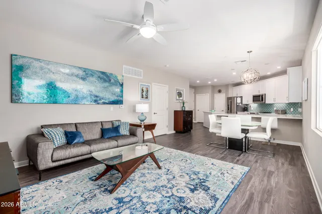 a living room with furniture and a view of kitchen