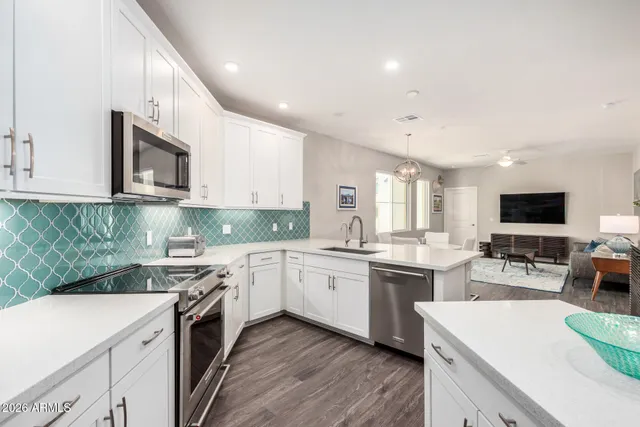 a kitchen with stainless steel appliances granite countertop a sink dishwasher stove and oven