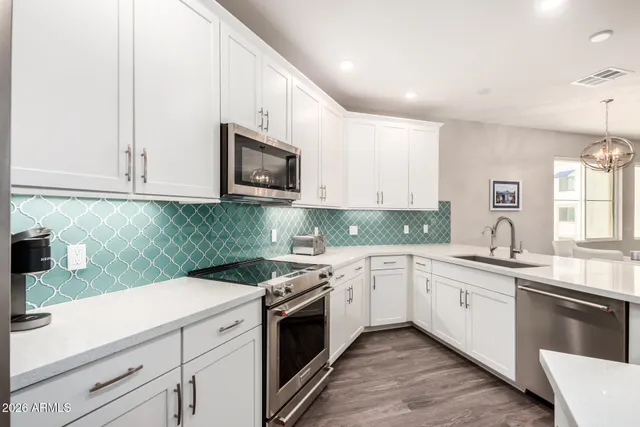 a kitchen with granite countertop white cabinets and white appliances