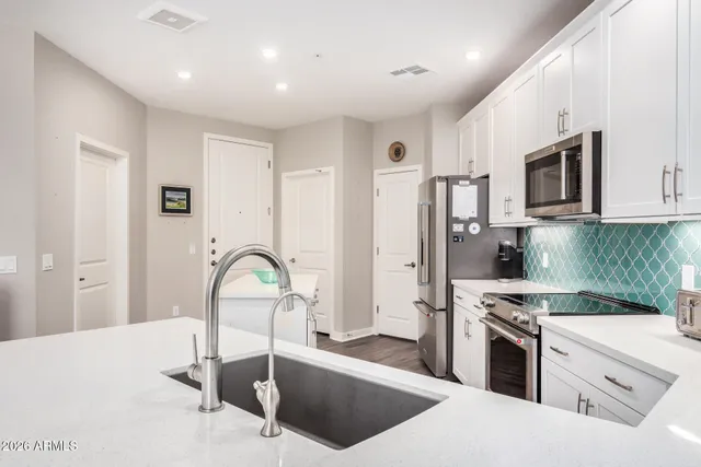 a kitchen with stainless steel appliances kitchen island granite countertop a stove a sink and a refrigerator