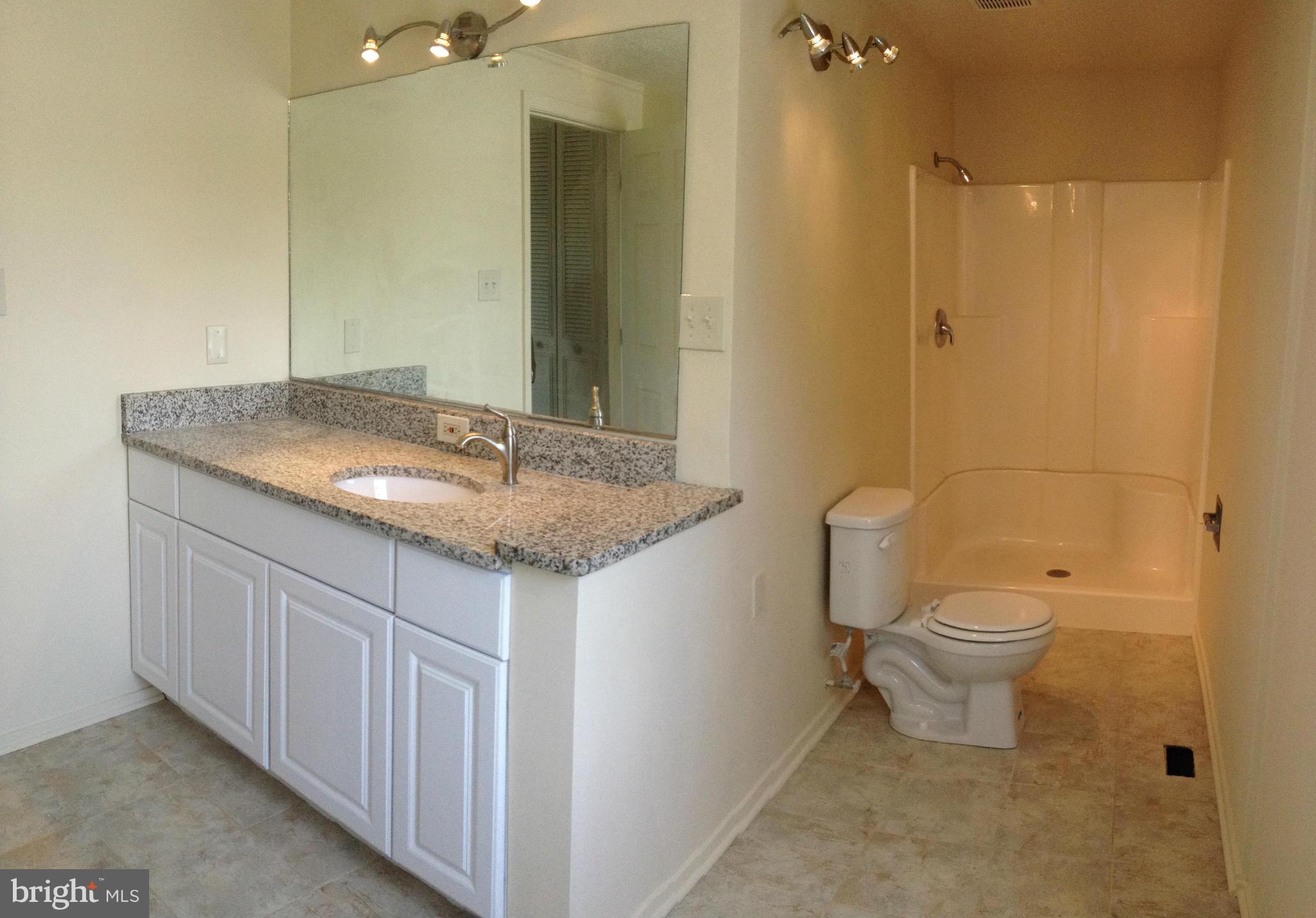 6432 St Phillips Road Linthicum, MD 21090 - Photo 19 of 27 a bathroom with a granite countertop sink a toilet and a mirror