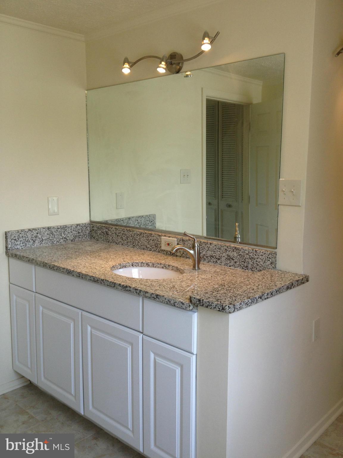 6432 St Phillips Road Linthicum, MD 21090 - Photo 20 of 27 a bathroom with a granite countertop sink and a mirror