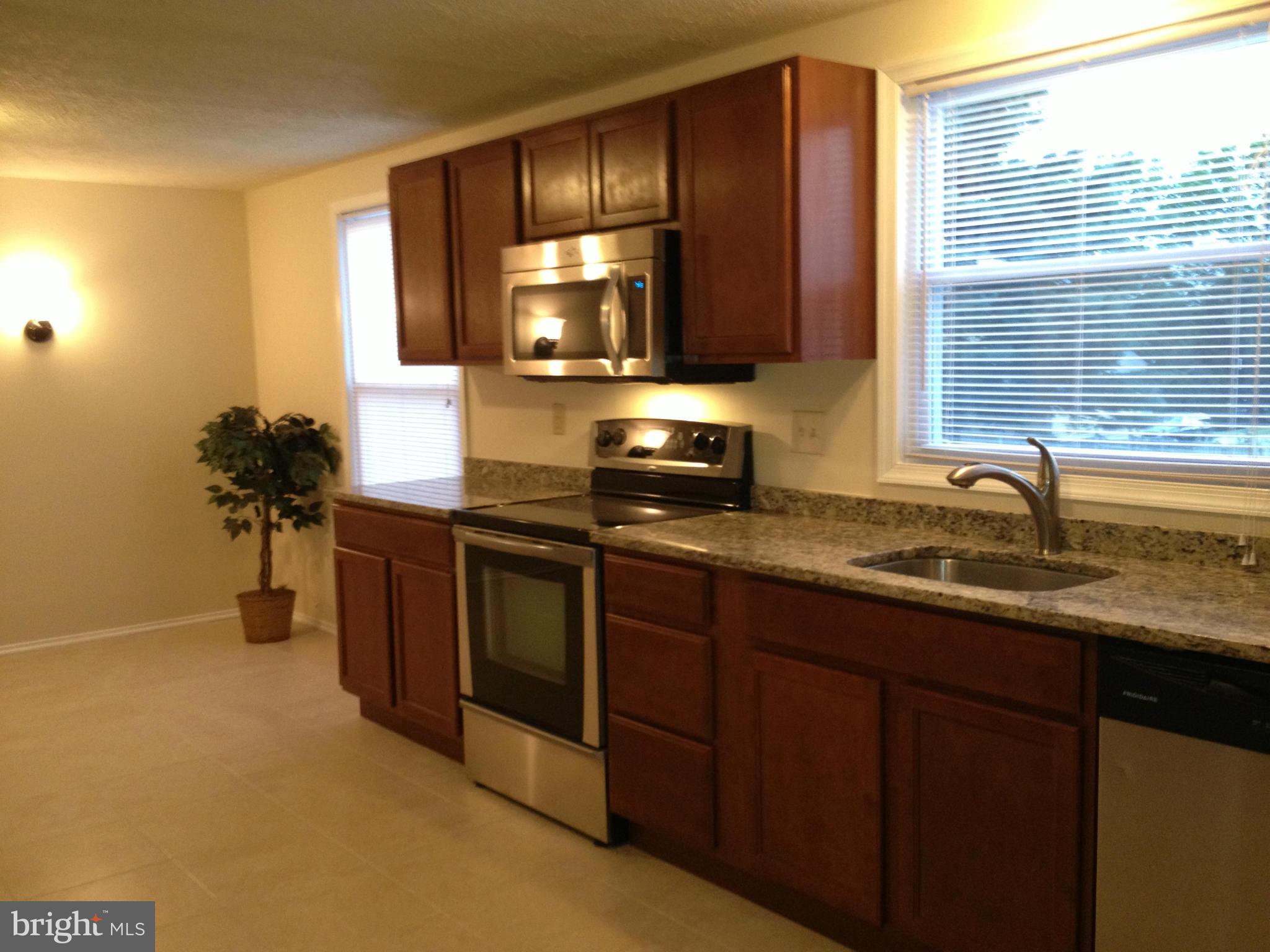 6432 St Phillips Road Linthicum, MD 21090 - Photo 9 of 27 a kitchen with stainless steel appliances granite countertop a sink and a stove