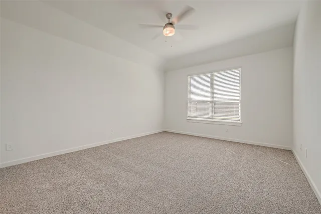 an empty room with a window and ceiling fan