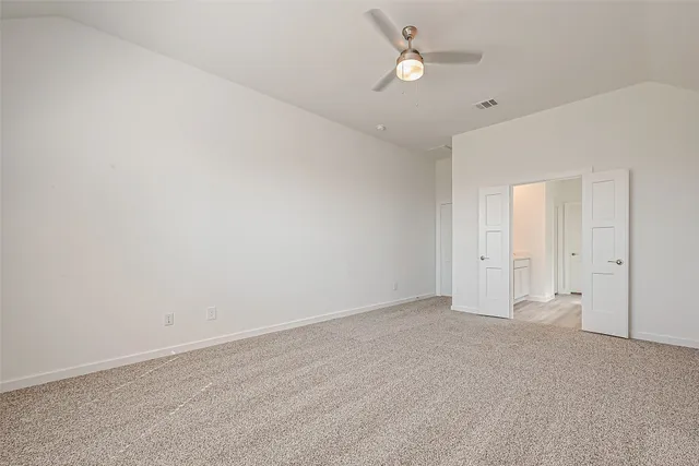 an empty room with a ceiling fan and a window