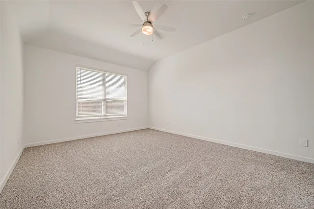 an empty room with a window and ceiling fan