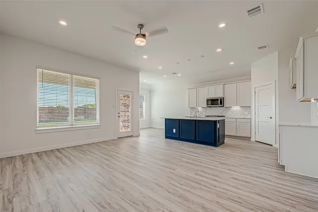 a large kitchen with stainless steel appliances granite countertop a stove a sink and a refrigerator