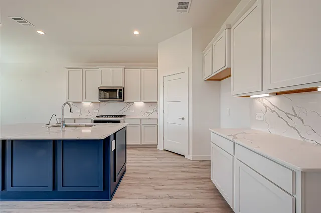 a kitchen with a sink appliances and cabinets