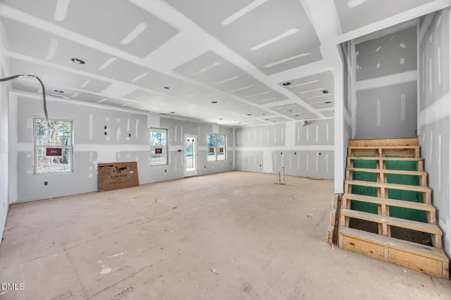 a view of empty room with staircase and wooden walls