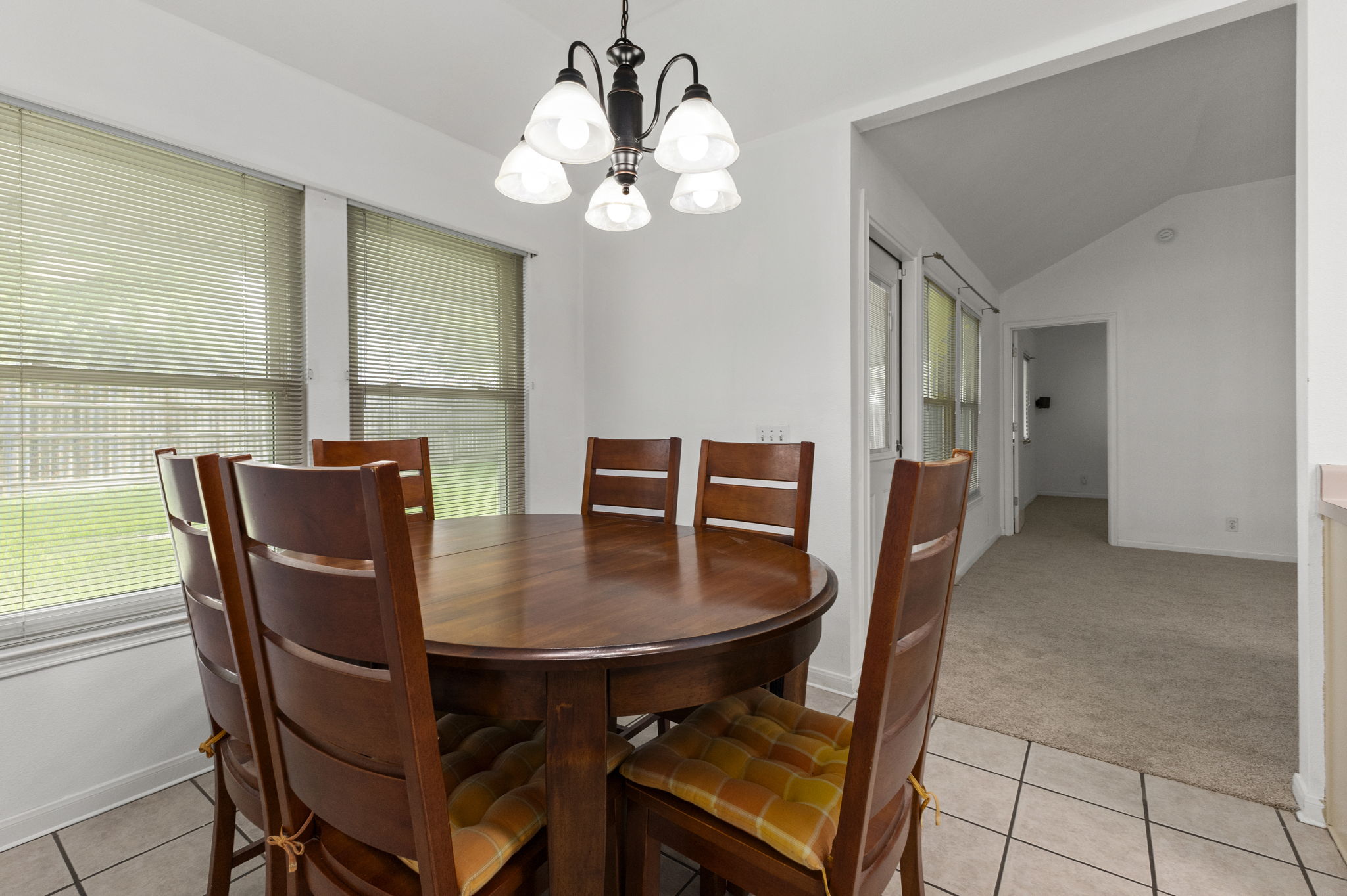 290 Bailey Loop Kyle, TX 78640 - Photo 13 of 33 Dining area featuring a contemporary chandelier, two windows with blinds, and tile flooring