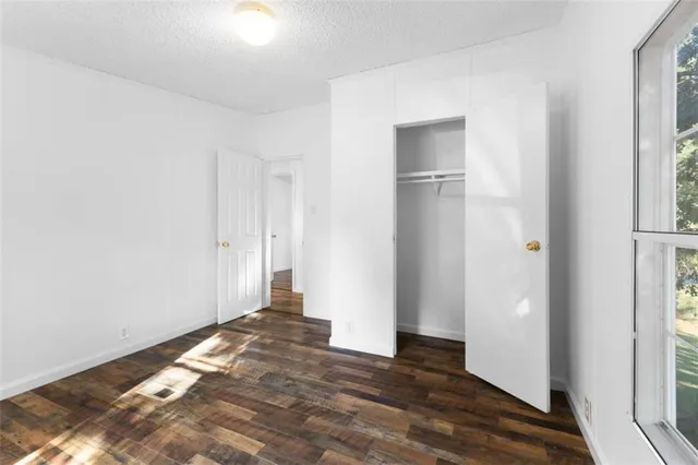 a view of a room with wooden floor and a window