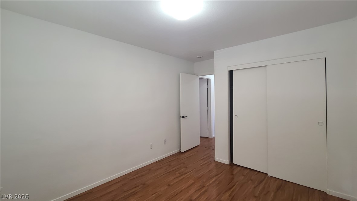 8944 Rutherford Grove Street Las Vegas, NV 89148 - Photo 30 of 35 Hardwood floors and bright white walls define this well-lit room, featuring a convenient sliding closet.