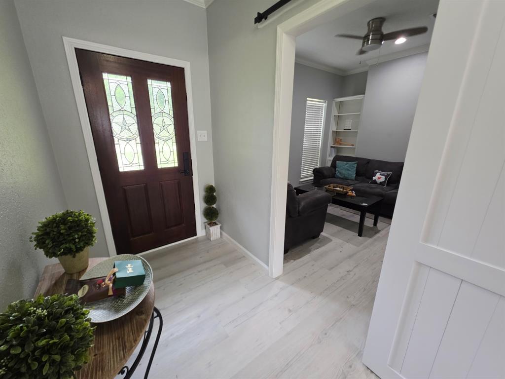 520 Red River Road Belton, TX 76513 - Photo 7 of 36 Entryway featuring a dark wood door with decorative glass inserts, light wood-finish flooring, and crown molding