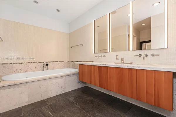 a bathroom with a bathtub a sink and a mirror