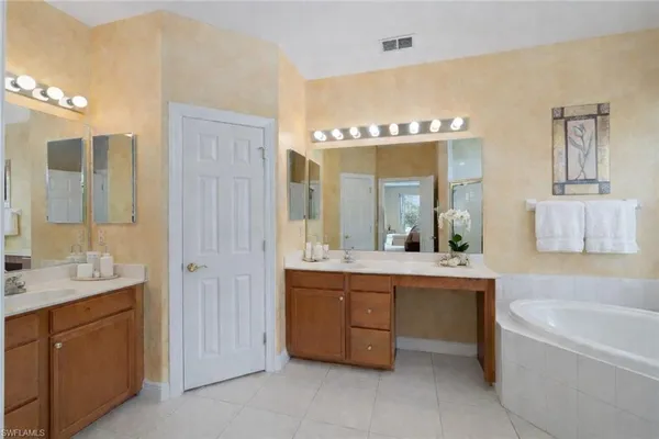 a bathroom with a tub sink and mirror
