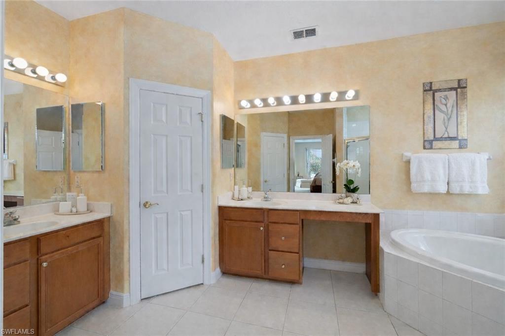 4832 Cerromar Drive Naples, FL 34112 - Photo 11 of 30 a bathroom with a tub sink and mirror