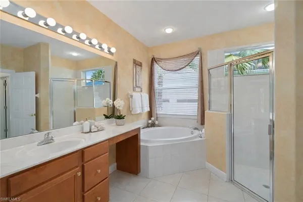 a bathroom with a tub a sink and mirror