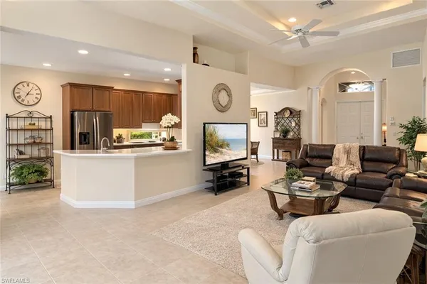 a living room with furniture kitchen view and a window