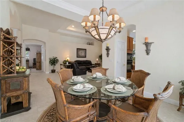 a view of a dining room with furniture a chandelier and wooden floor