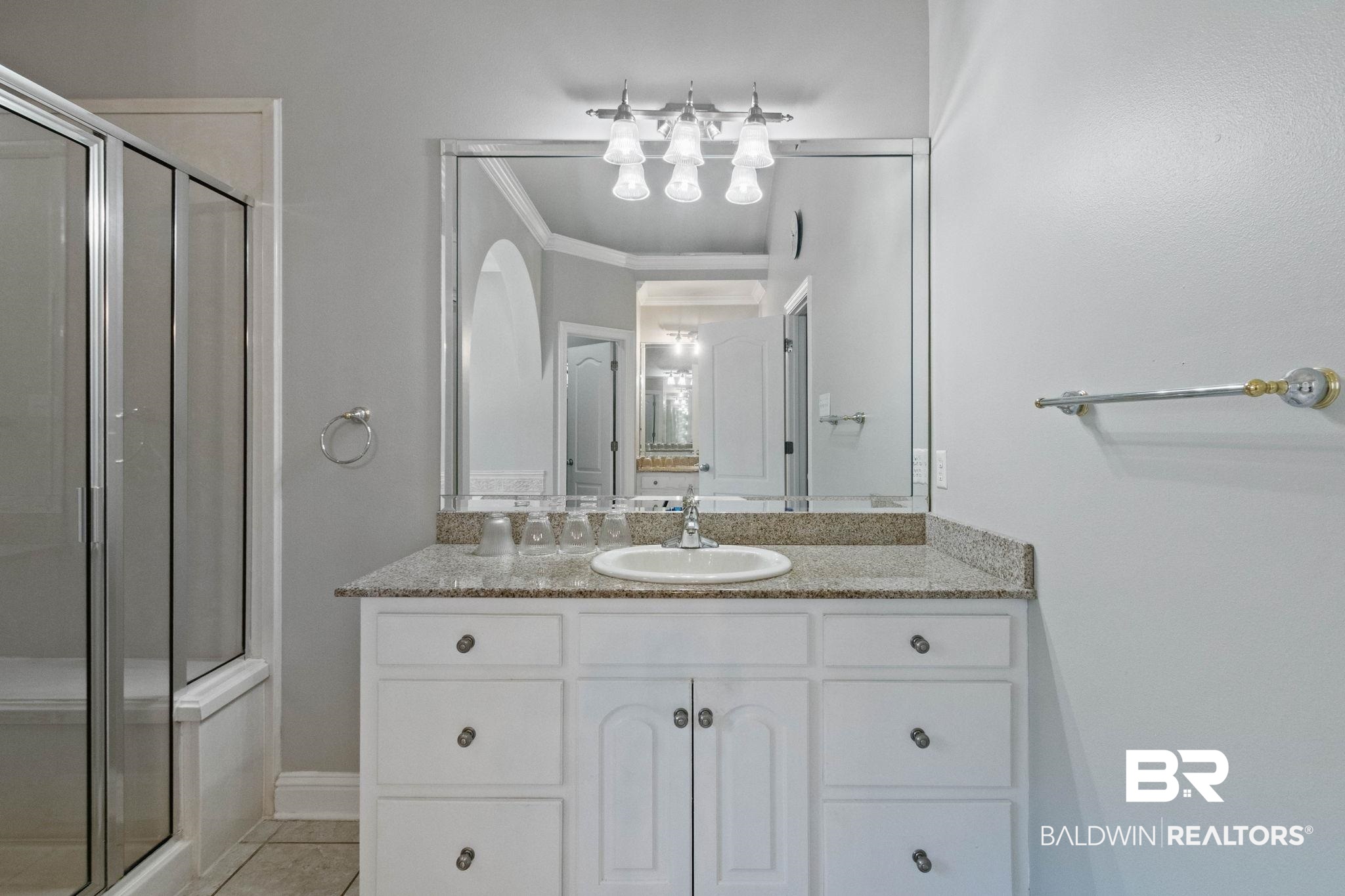 3176 Cedar Court Mobile, AL 36619 - Photo 18 of 33 Bathroom vanity featuring a white cabinet with paneled doors and drawers, a light-colored countertop, and an integrated sink with a chrome faucet