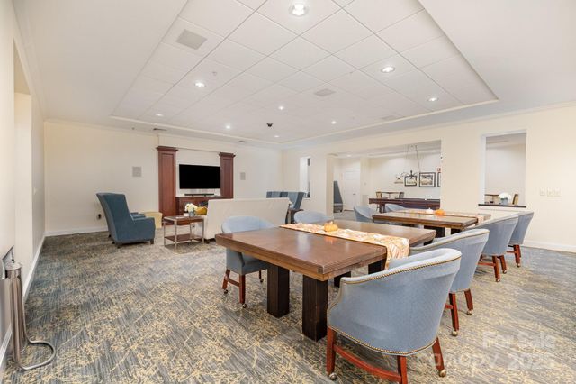 a dining hall with stainless steel appliances granite countertop a sink and chairs