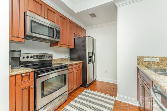 a kitchen with stainless steel appliances granite countertop a stove microwave and refrigerator