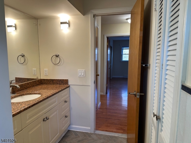 244 Olivia Street Ridgewood, NJ 07450 - Photo 26 of 43 a bathroom with a granite countertop sink a mirror and a shower