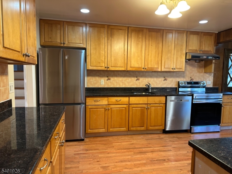 244 Olivia Street Ridgewood, NJ 07450 - Photo 8 of 43 a kitchen with a refrigerator a stove top oven and cabinets
