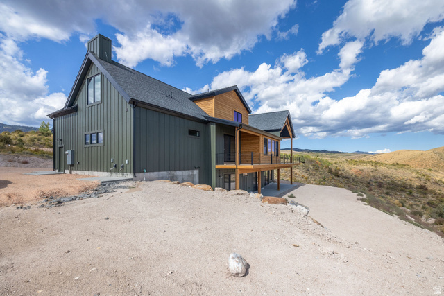 300 Knoll Loop, Unit 227 Fish Haven, ID 83287 - Photo 4 of 56 View of side of home with a shingled roof, a porch, and a mountain view