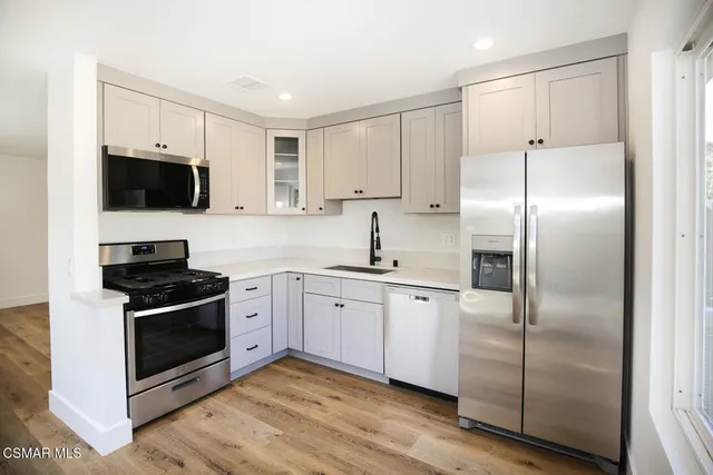 a kitchen with cabinets stainless steel appliances and a counter space