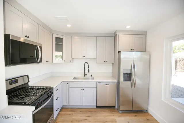 a kitchen with stainless steel appliances a refrigerator stove and sink