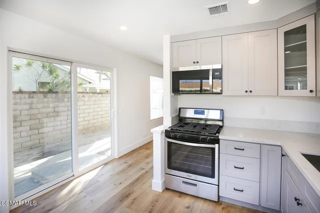 a kitchen with white cabinets and appliances