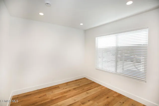 a view of a room with a window and wooden floor